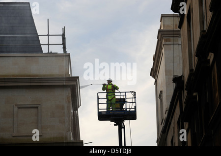 Un constructeur dans une grue de pulvériser la façade de la baignoire centre commercial Southgate, Somerset UK Banque D'Images