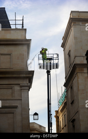 Un constructeur dans une grue de pulvériser la façade de la baignoire centre commercial Southgate, Somerset UK Banque D'Images