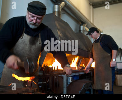 Blacksmith Ruediger Schwenk travaille sur un fer à repasser rose avec ses bénévoles dans son atelier de Aarbergen-Kettenbach, Allemagne, 24 novembre 2012. Les roses faits à partir du fer sera envoyé à la Norvège où elles seront utilisées avec d'autres roses d'artistes du monde entier de faire un monument pour les victimes de Utoya. Photo : Boris Roessler Banque D'Images