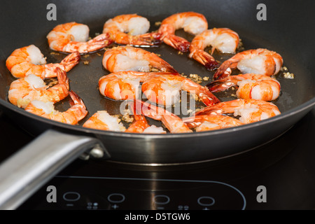 Crevettes frites dans la poêle sur la cuisinière Banque D'Images