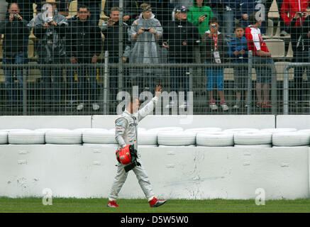 (Dossier) - Un fichier photo datée du 20 juillet 2012 montre l'Allemand Michael Schumacher, pilote de Formule 1 en agitant à l'auditoire après un accident au cours de la deuxième session de formation du Grand Prix d'Allemagne à Hockenheim race track à Hockenheim, Allemagne. 43 ans, Schumacher a annoncé le 04 octobre 2012 à Suzuka, qu'il mettra fin à sa carrière après la saison en cours. Photo : Jens Buettne Banque D'Images