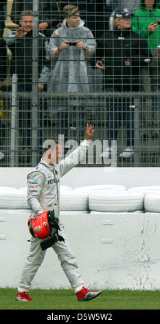 (Dossier) - Un fichier photo datée du 20 juillet 2012 montre l'Allemand Michael Schumacher, pilote de Formule 1 en agitant à l'auditoire après un accident au cours de la deuxième session de formation du Grand Prix d'Allemagne à Hockenheim race track à Hockenheim, Allemagne. 43 ans, Schumacher a annoncé le 04 octobre 2012 à Suzuka, qu'il mettra fin à sa carrière après la saison en cours. Photo : Jens Buettne Banque D'Images
