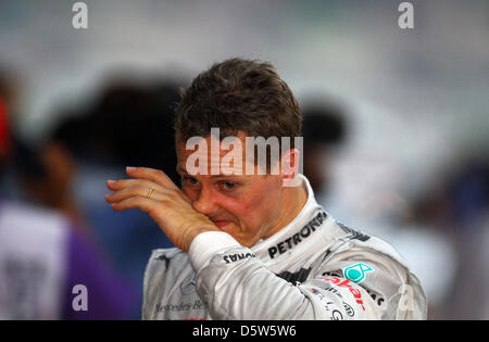 Fichier) - Un fichier photo datée du 25 mars 2012 montre l'Allemand Michael Schumacher, pilote de Formule 1 essuyant le visage au parc ferme après le Grand Prix de Malaisie a tenu à la piste de course de Sepang à Kuala Lumpur, Malaisie. 43 ans, Schumacher a annoncé le 04 octobre 2012 à Suzuka, qu'il mettra fin à sa carrière après la saison en cours. Photo : Jens Buettner Banque D'Images