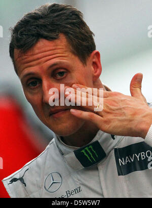 Fichier) - Un fichier photo datée du 25 mars 2012 montre l'Allemand Michael Schumacher, pilote de Formule 1 essuyant le visage au parc ferme après le Grand Prix de Malaisie a tenu à la piste de course de Sepang à Kuala Lumpur, Malaisie. 43 ans, Schumacher a annoncé le 04 octobre 2012 à Suzuka, qu'il mettra fin à sa carrière après la saison en cours. Photo : Jens Buettner Banque D'Images