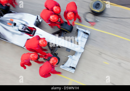 Racing team working at pit stop Banque D'Images