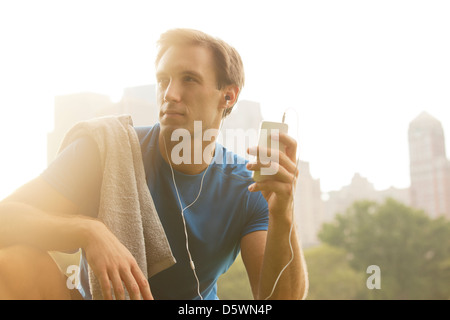 Runner listening to mp3 player in park Banque D'Images