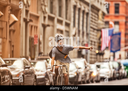 Man riding bicycle on city street Banque D'Images