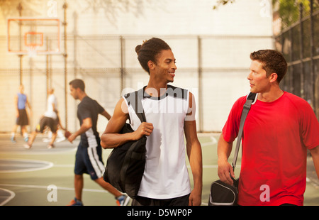 Hommes parler sur un terrain de basket-ball Banque D'Images