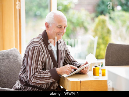 Older Man using tablet computer at table Banque D'Images