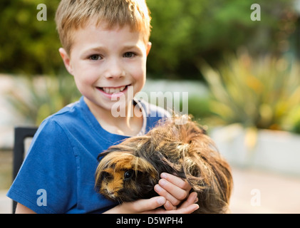 Smiling boy holding cochon d'extérieur Banque D'Images