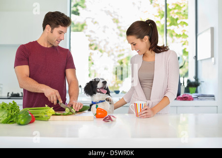 Chien avec couple cooking in kitchen Banque D'Images