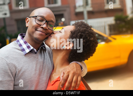 Couple kissing on city street Banque D'Images