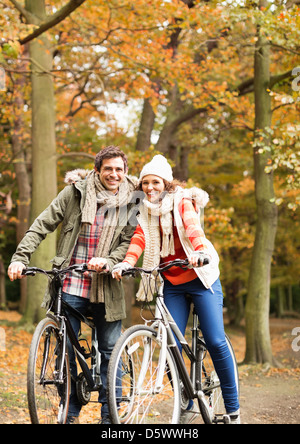 Couple riding bicycles together in park Banque D'Images