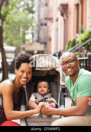 Family smiling together on city street Banque D'Images