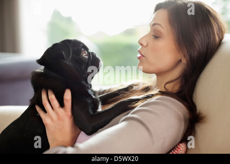 Woman relaxing with dog on sofa Banque D'Images