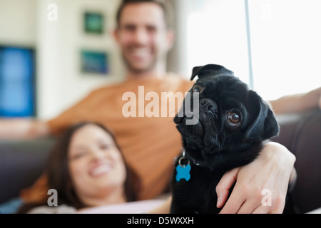 Couple relaxing with dog on sofa Banque D'Images