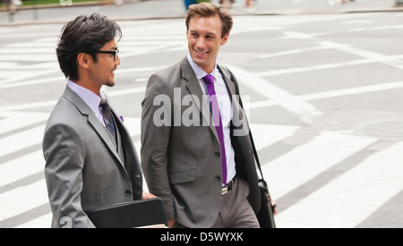 Businessmen talking on city street Banque D'Images