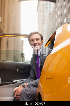 Businessman sitting in taxi on city street Banque D'Images