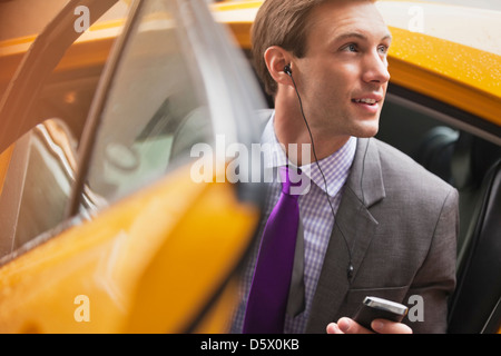 Businessman climbing out of taxi Banque D'Images