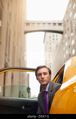 Businessman climbing out of taxi Banque D'Images