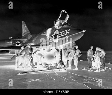 Le personnel charge un réservoir de carburant sur un Douglas A4D-2 SkyHawk de l'escadron d'attaque (va) 34 sur le pont d'envol de l'USS Saratoga (CVA-60) en 1959. L'A4D-2 Skyhawk était un avion d'attaque à porte-avions utilisé par l'US Navy. Banque D'Images