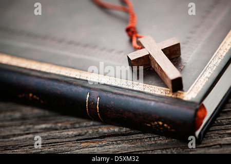 Gros plan du collier croix chrétienne en bois simple sur la sainte Bible Banque D'Images