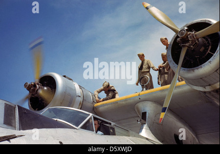 Un mécanicien travaille sur le moteur d'un hydravion Consolidated PBY 'Catalina' à la base aérienne navale de Corpus Christi en août 1942. Le moteur a démarré avec succès et le technicien sécurise le panneau d'accès. Banque D'Images