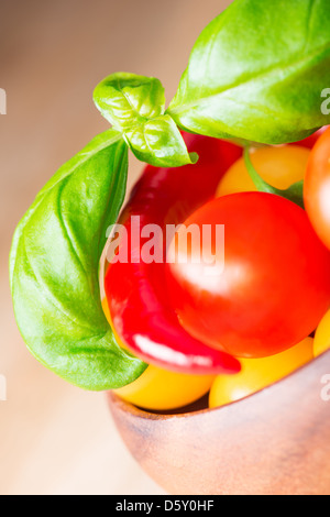 Feuilles de basilic avec les tomates cerise et poivre Banque D'Images