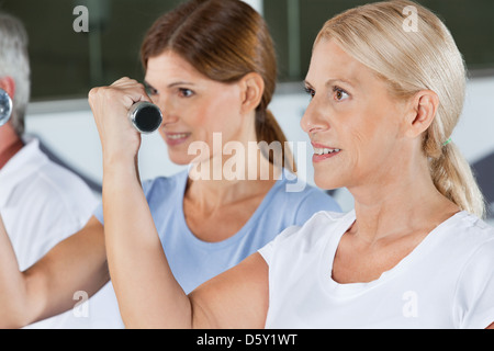 Les femmes âgées faisant l'entraînement des haltères courts in gym Banque D'Images