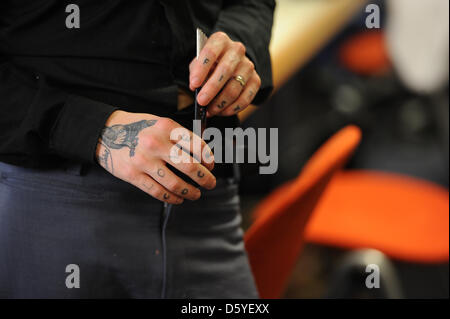 Vue de la mains tatouées de Lady Gaga styliste Charlie Le Mindu à la tendance coiffure show 'Vision 2013' à l'hôtel Estrel à Berlin, Allemagne, 22 octobre 2012. Photo : Jens Kalaene Banque D'Images