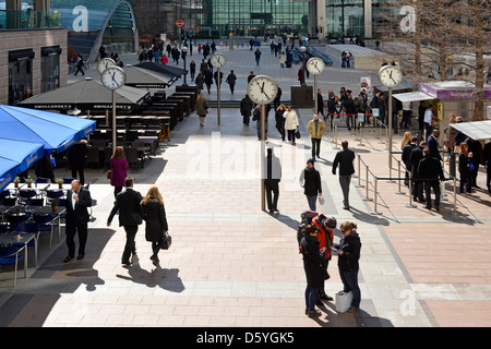 Canary Wharf horloges sur la plaza avec les employés de bureau à l'heure du déjeuner Docklands Tower Hamlets East London England UK Banque D'Images