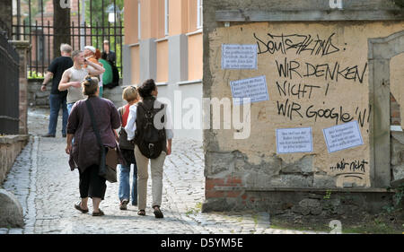 Les piétons passent devant un graffiti sur un mur de la maison qui se lit comme suit : "Nous ne pensons pas ! Nous Google !" à Weimar, Allemagne, 18 septembre 2012. Photo : Martin Schutt Banque D'Images