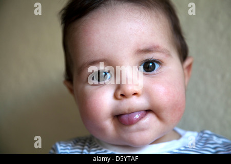 Portrait Bébé garçon avec la langue qui sort Banque D'Images