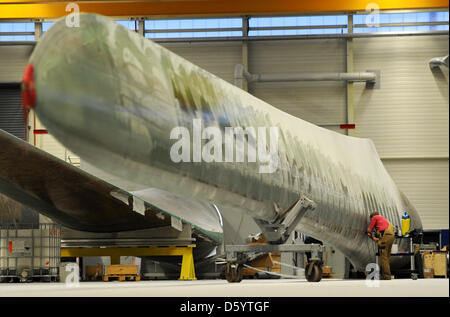 Un employé travaille sur une pale de rotor à l'usine de fabrication de pales de rotor d'entreprise Nordex à Rostock, Allemagne, 02 novembre 2012. Le fabricant de technologie d'énergie éolienne est à 130 nouveaux empoyees à Rostock le site. Cela a été annoncé par la société le 02 novembre 2012. La société a l'intention d'augmenter e emanufature des pales du rotor. Photo : DANIEL REINHARDT Banque D'Images