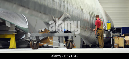 Un employé travaille sur une pale de rotor à l'usine de fabrication de pales de rotor d'entreprise Nordex à Rostock, Allemagne, 02 novembre 2012. Le fabricant de technologie d'énergie éolienne est à 130 nouveaux empoyees à Rostock le site. Cela a été annoncé par la société le 02 novembre 2012. La société a l'intention d'augmenter e emanufature des pales du rotor. Photo : DANIEL REINHARDT Banque D'Images