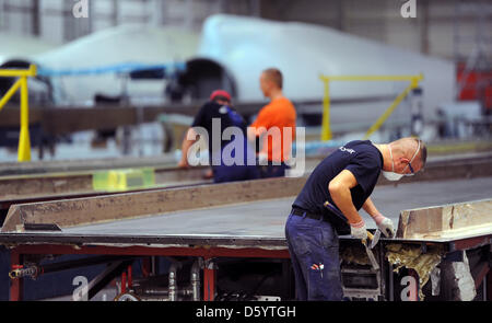 Un employé travaille sur une pale de rotor à l'usine de fabrication de pales de rotor d'entreprise Nordex à Rostock, Allemagne, 02 novembre 2012. Le fabricant de technologie d'énergie éolienne est à 130 nouveaux empoyees à Rostock le site. Cela a été annoncé par la société le 02 novembre 2012. La société a l'intention d'augmenter e emanufature des pales du rotor. Photo : DANIEL REINHARDT Banque D'Images