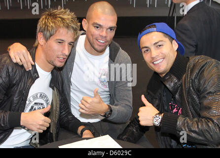 Un cadeau photo prise le 8 novembre 2012 montre les joueurs du Real Madrid Ronaldo Fabio Coentrao (l), Pepe (M) et Ronaldo (r) à la piste de course à Madrid, Espagne. Joueurs et choaches ont reçu leurs nouveaux véhicules officiels de l'équipe promoteur. L'événement a été ouvert au public et assisté par un grand groupe de personnes. Photo : Karl-Josef Opim Banque D'Images