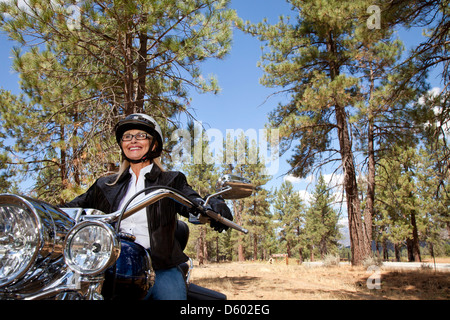 Senior woman riding through forest Banque D'Images