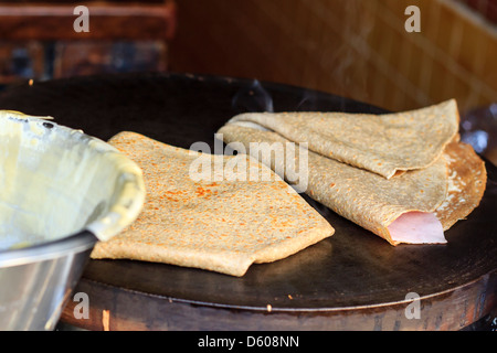 Crêpes salées français sur une plaque chauffante avec jambon et fromage prêt à aller Banque D'Images
