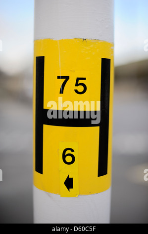 H jaune d'incendie Emplacement sur un lampadaire montrant diamètre de conduite principale d'eau et pas de signe, Pays de Galles, Royaume-Uni. Banque D'Images