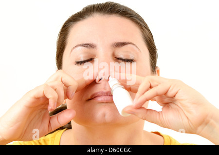 Femme à l'aide de spray nasal Banque D'Images