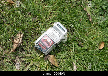 Paquet de cigarettes vides jetés avec code à barres et d'avertissement de santé sur l'herbe Banque D'Images