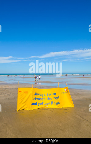 La vie de la RNLI signe garde les nageurs d'avertissement de rester entre les drapeaux sur Westward Ho ! Plage, Devon, Angleterre. Banque D'Images