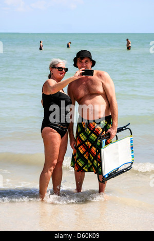 Couple qui n'y propre photo à l'aide d'un iPhone tout en en vacances à Sanibel Island Florida Banque D'Images