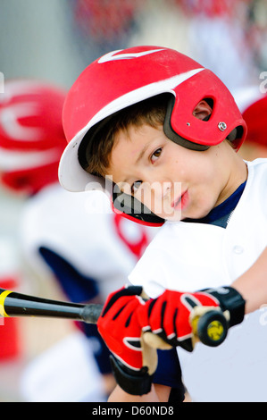 La petite ligue de baseball player swinging le bat de près. Banque D'Images