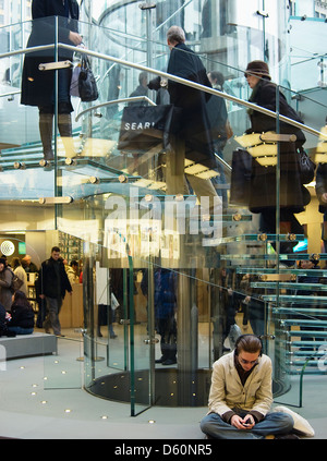 Un homme joue sur son ipod pendant l'attente à l'apple store, 5e avenue new york city Banque D'Images