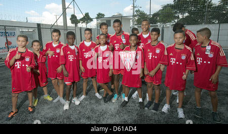 Les enfants vêtus de leurs nouveaux maillots du FC Bayern Muinich, qu'il avait reçues de la part d'anciens joueurs de football professionnels du club de Bundesliga, Paulo Sergio et Paul Breitner (pas en photo), posent pour la caméra à proximité le stade de soccer 'Arena' Corinthiens à Sao Paulo, Brésil, 11 avril 2012. Le match d'ouverture de la Coupe du Monde de la FIFA 2012 a lieu au stade. Le Premier Ministre bavarois S Banque D'Images