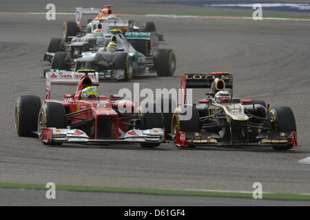 Pilote de formule 1 finlandais Kimi Raikkonen (R) de Lotus tente de dépasser Felipe Massa brésilien de Ferrari durant le Grand Prix de Formule 1 de Bahreïn au Circuit International de Sakhir, près de Manama, Bahreïn, le 22 avril 2012. Photo : David Ebener dpa Banque D'Images