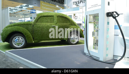 Une Coccinelle couvertes d'herbe est à côté d'une station de recharge pour voitures électriques au 'Hanover Messe" au centre des congrès d'Hanovre à Hanovre, Allemagne, 22 avril 2012. Environ 5 000 entreprises de 69 pays prennent part à la plus grande foire industrielle qui a lieu entre 23 et 27 avril 2012 à Hanovre. Cette année, le pays partenaire est la Chine. Photo : JULIAN STRATENSCHUL Banque D'Images