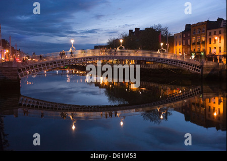 Vue horizontale de la Ha'penny Bridge aka Droichead na Leathphingine ou pont de la Liffey à Dublin au coucher du soleil. Banque D'Images